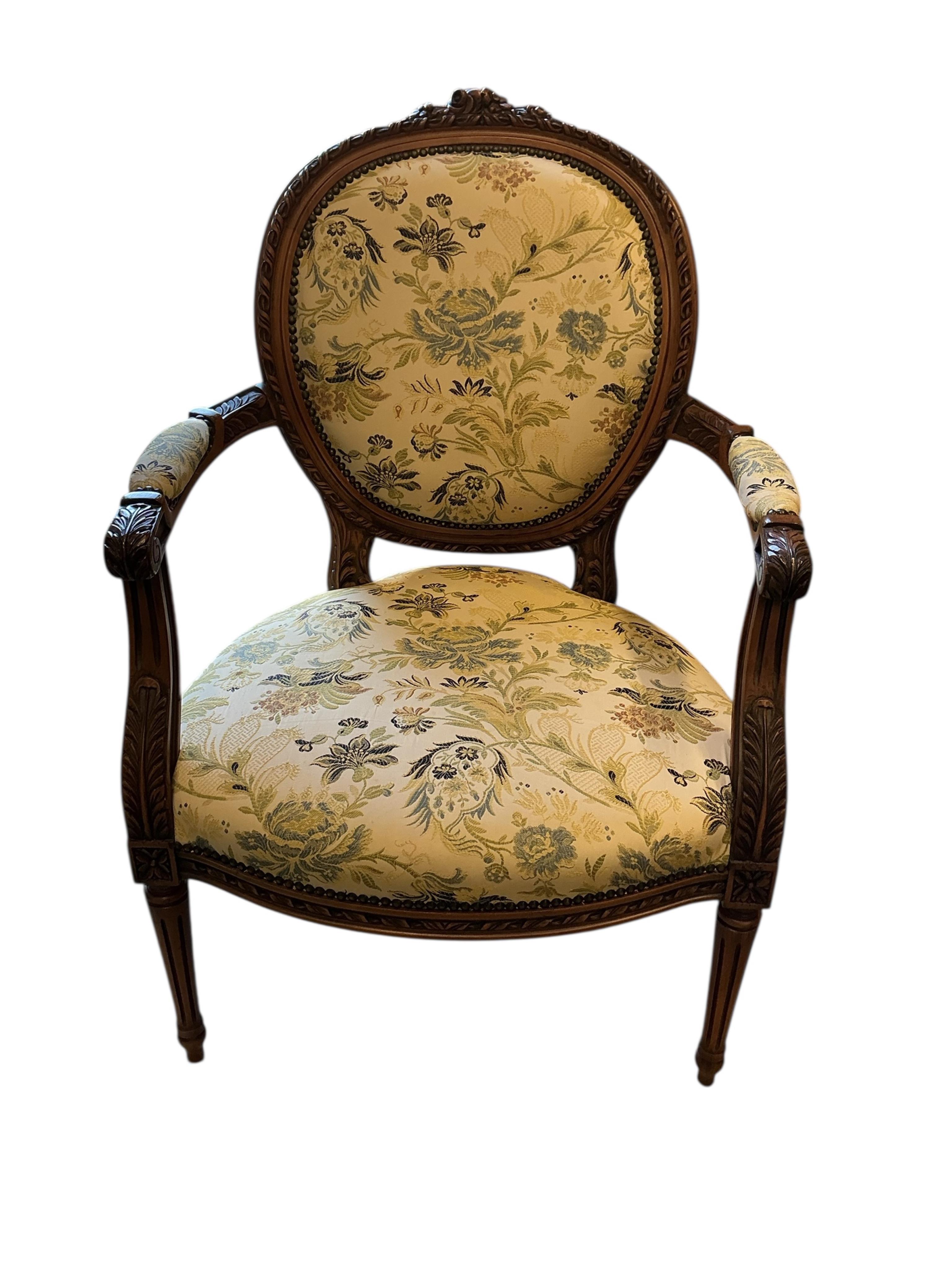 A reproduction Louis XVI style carved beech upholstered open armchair, width 65cm, depth 54cm, height 94cm